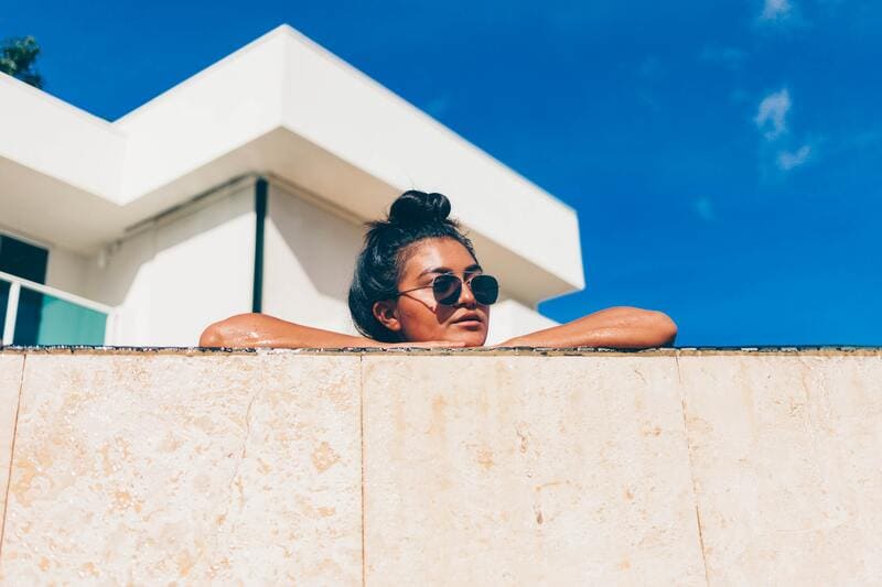 femme bronzant au bord de la piscine avec lunettes